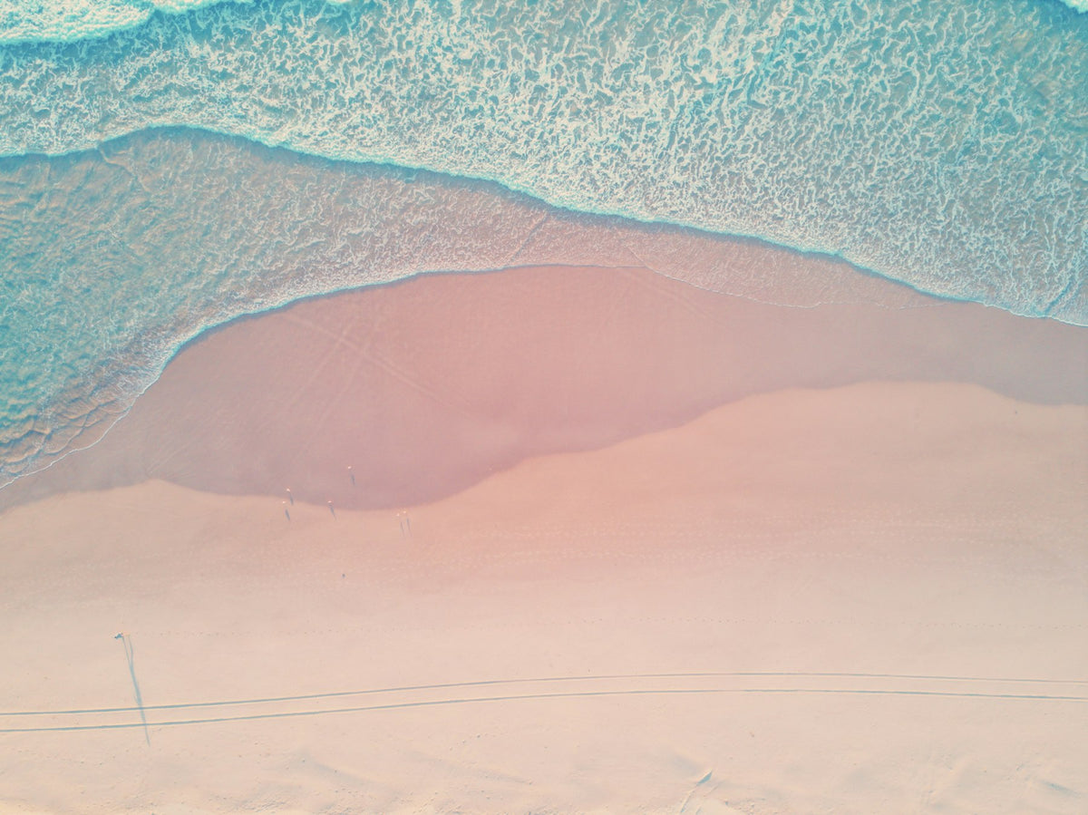 Plage de sable rose et vagues douces vues du ciel