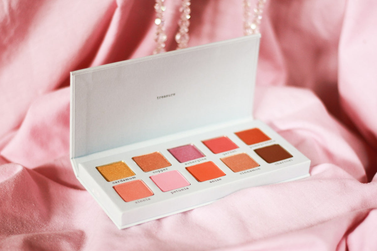 Palette de fards pastel sur tissu rose
