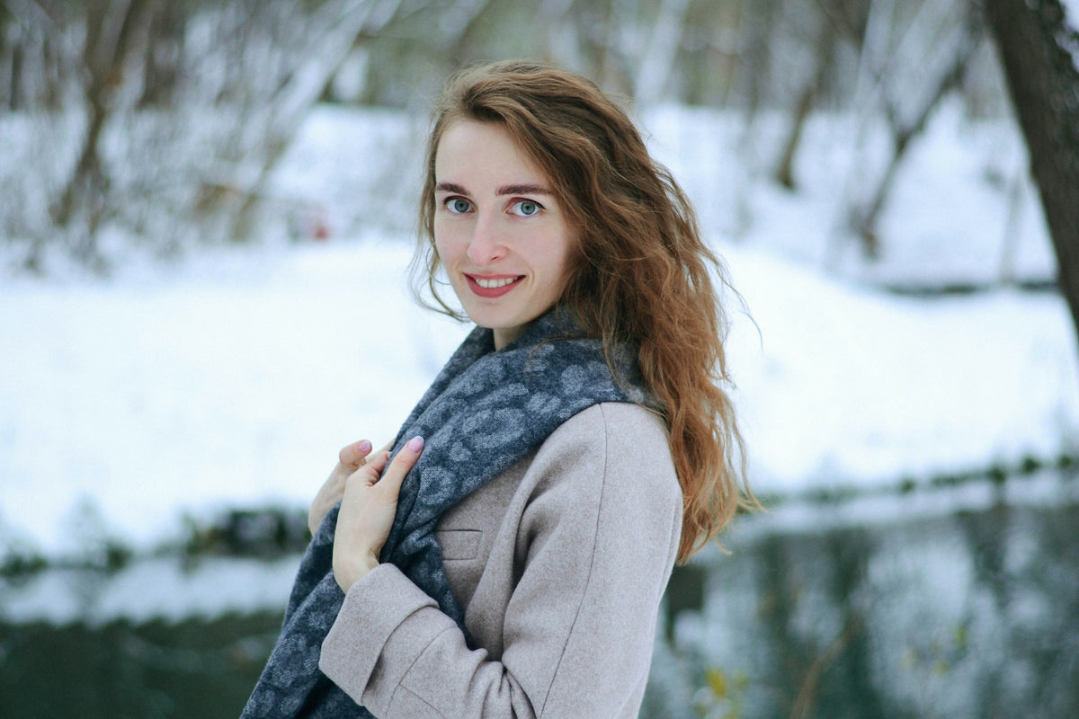 Jeune femme souriante en écharpe, en hiver