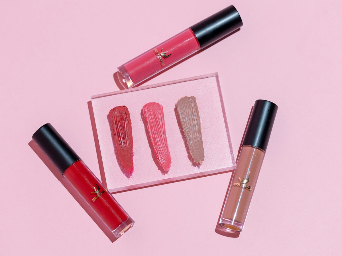 Rouges à lèvres et gloss sur fond rose Image