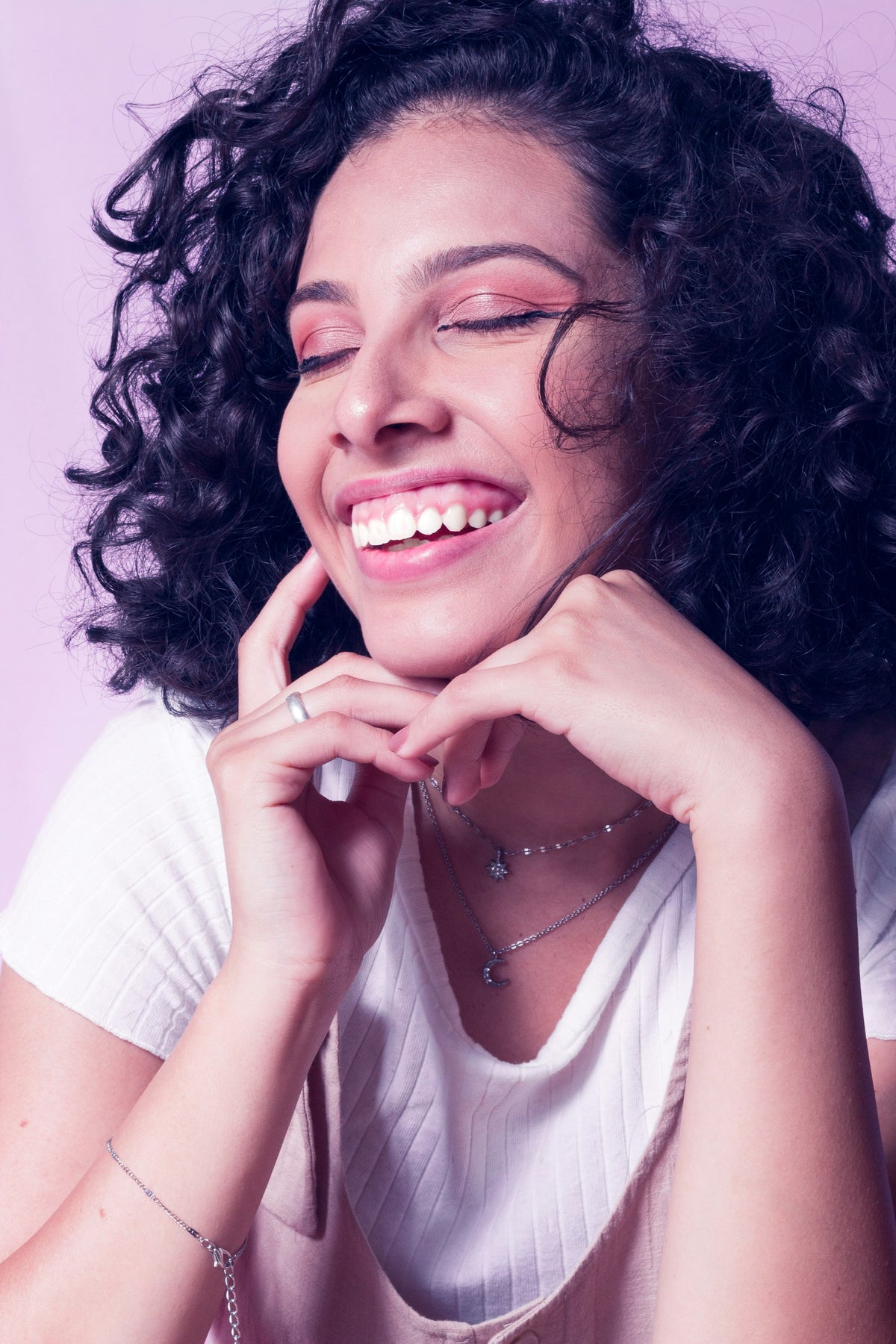 Jeune femme à la peau mate, souriante, cheveux bouclés Image