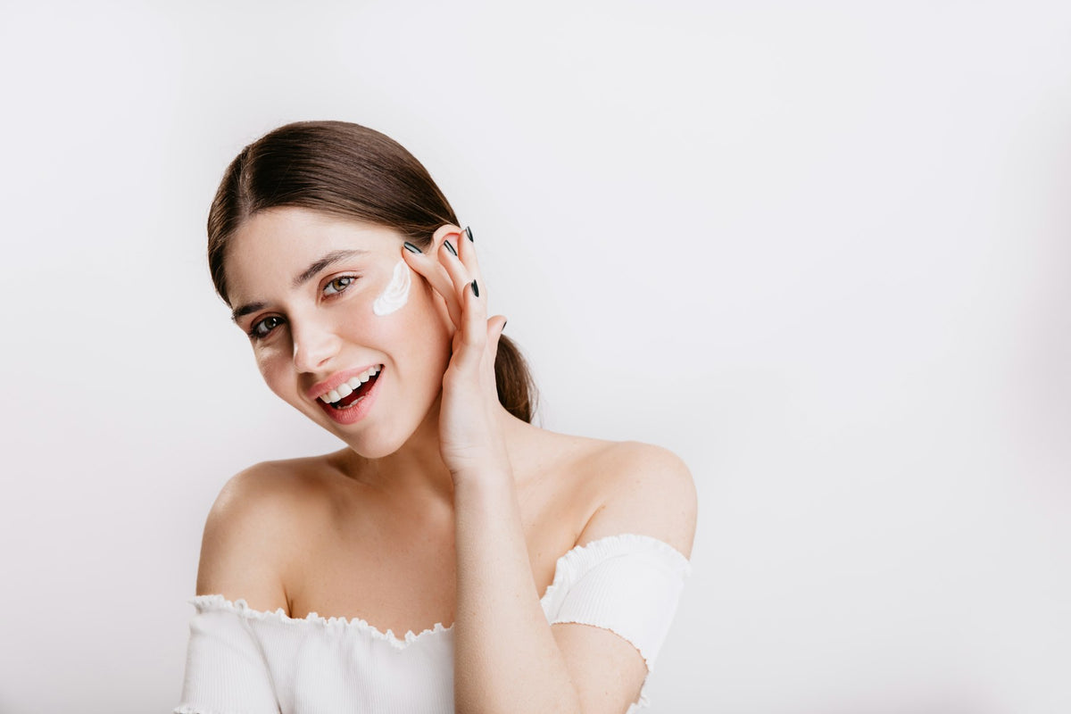 Jeune femme souriante qui prend soin de sa peau