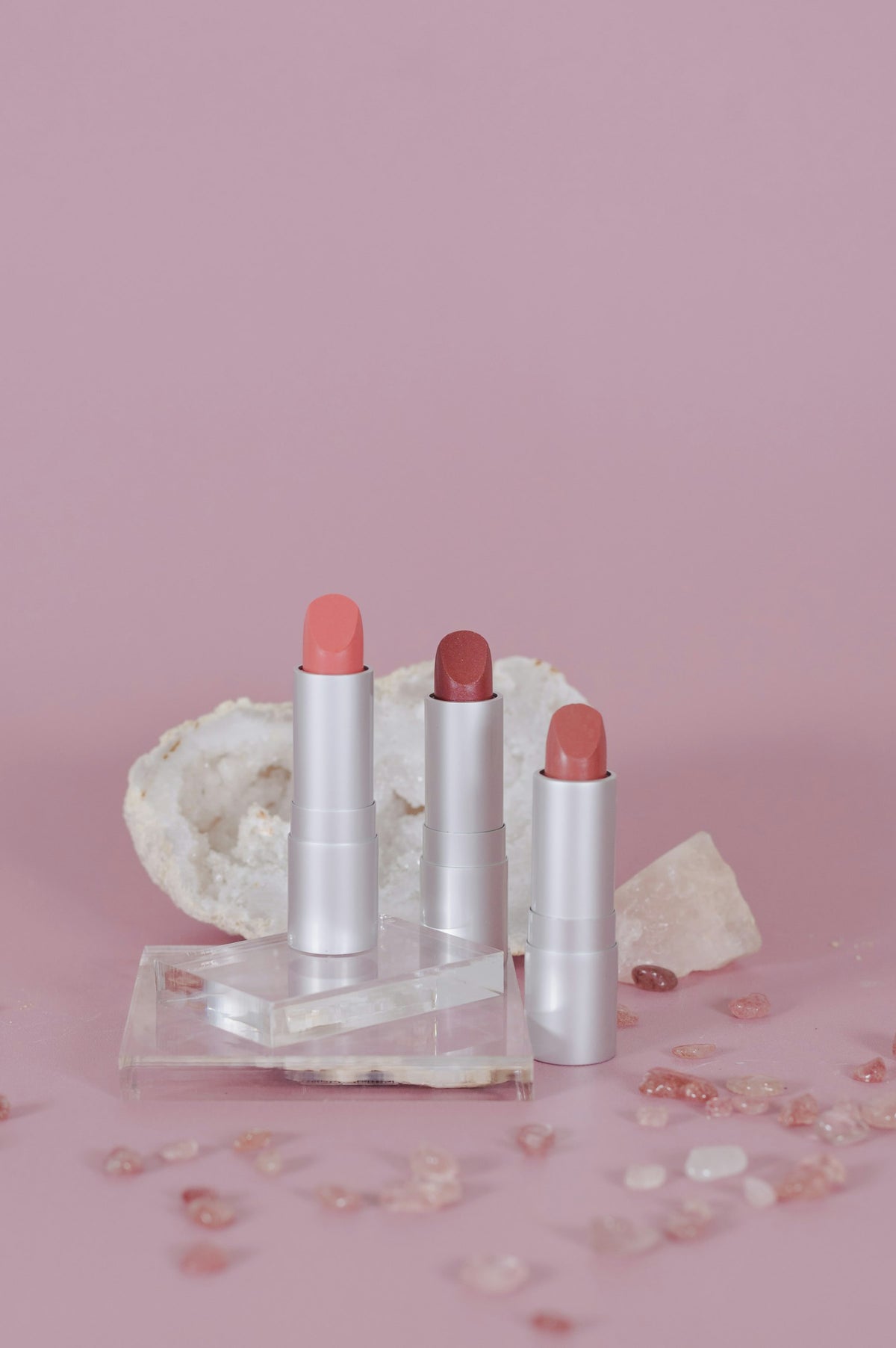 Rouges à lèvres nude posés sur une pierre claire